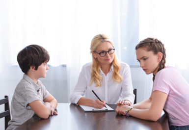 Une aide sociale à l'enfance et deux enfants profitant d'une assistance éducative